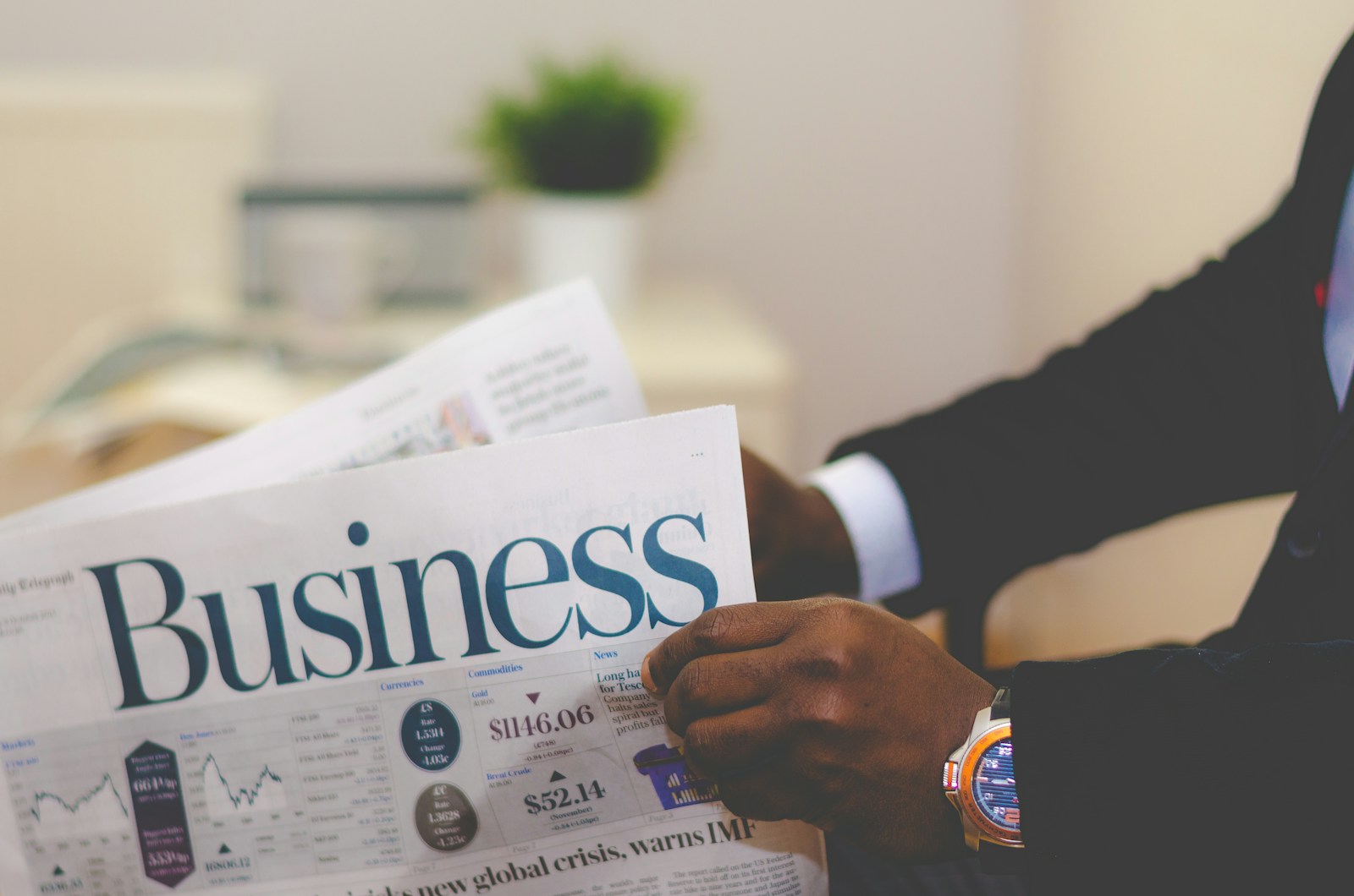 person wearing suit reading business, newspaper, business